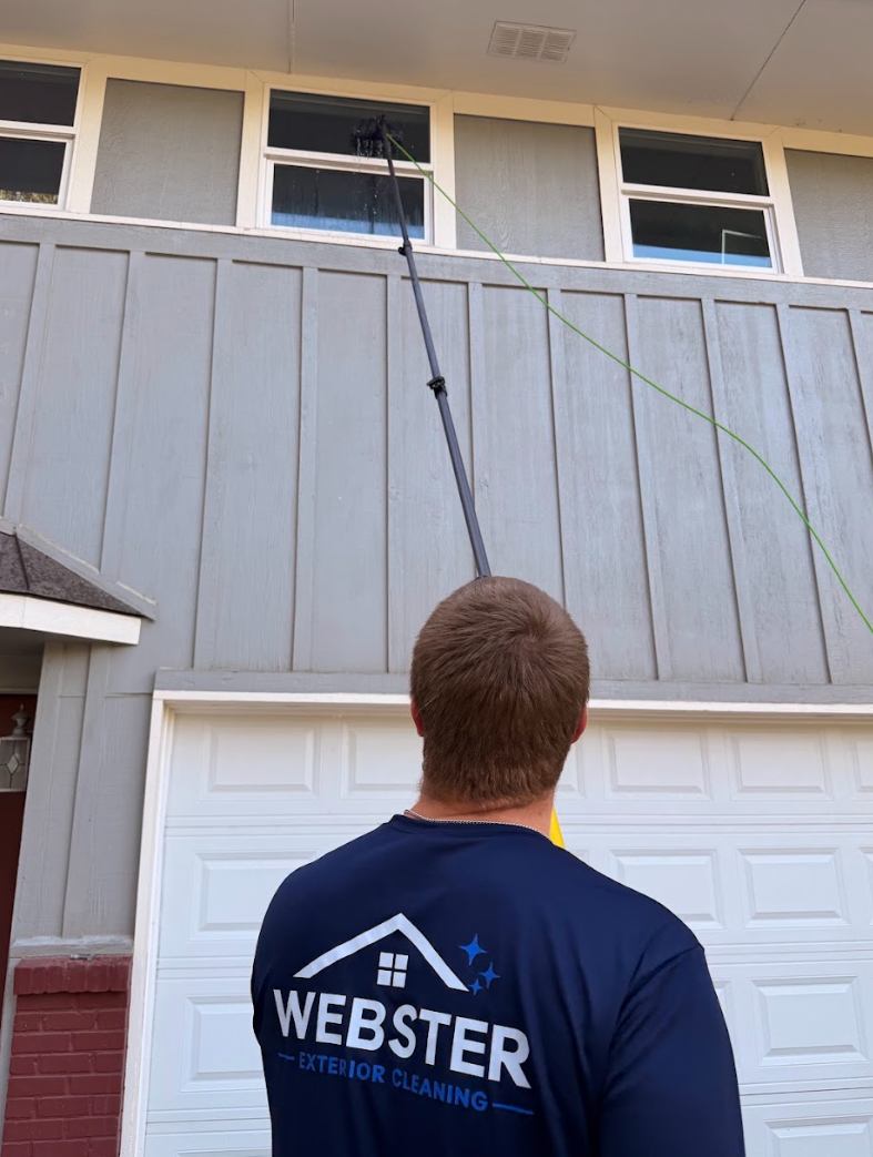 Webster Exterior Cleaning technician using a water-fed pole to clean upper-story windows
